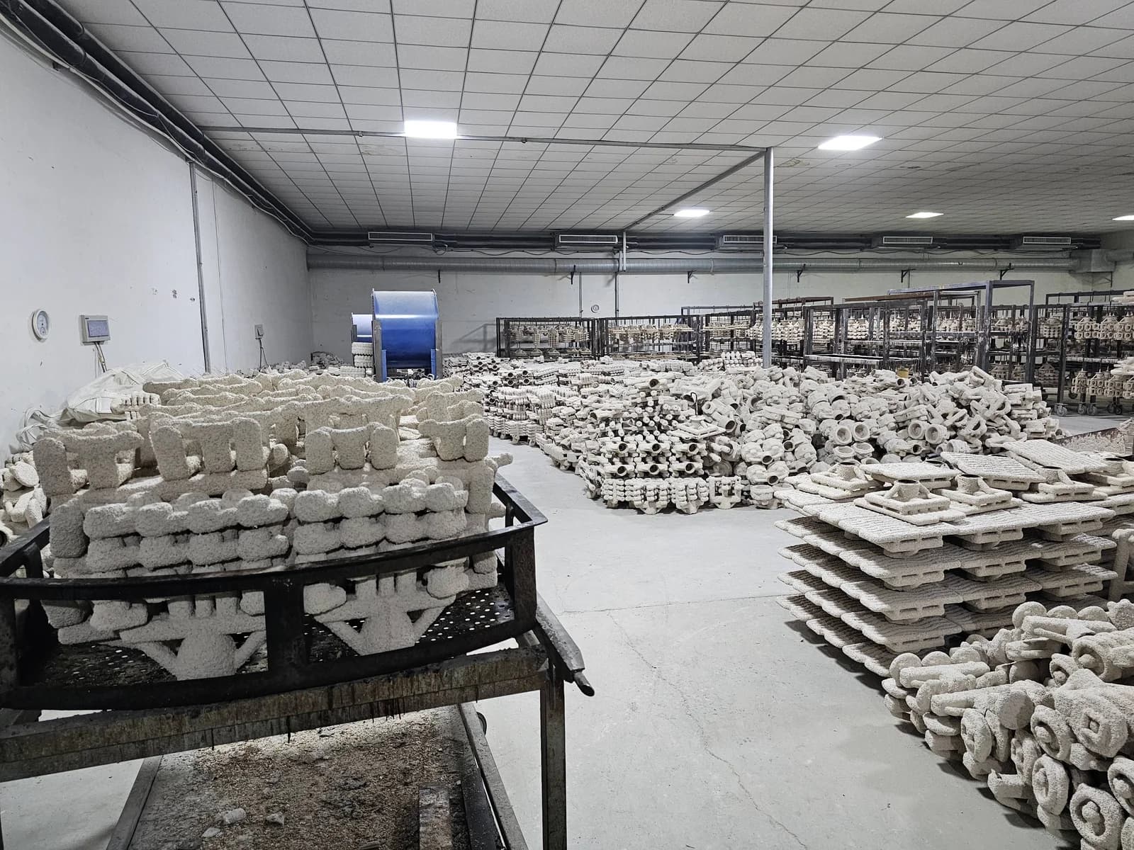 Moldes de conchas de cerámica dispuestos sobre bastidores en el taller.